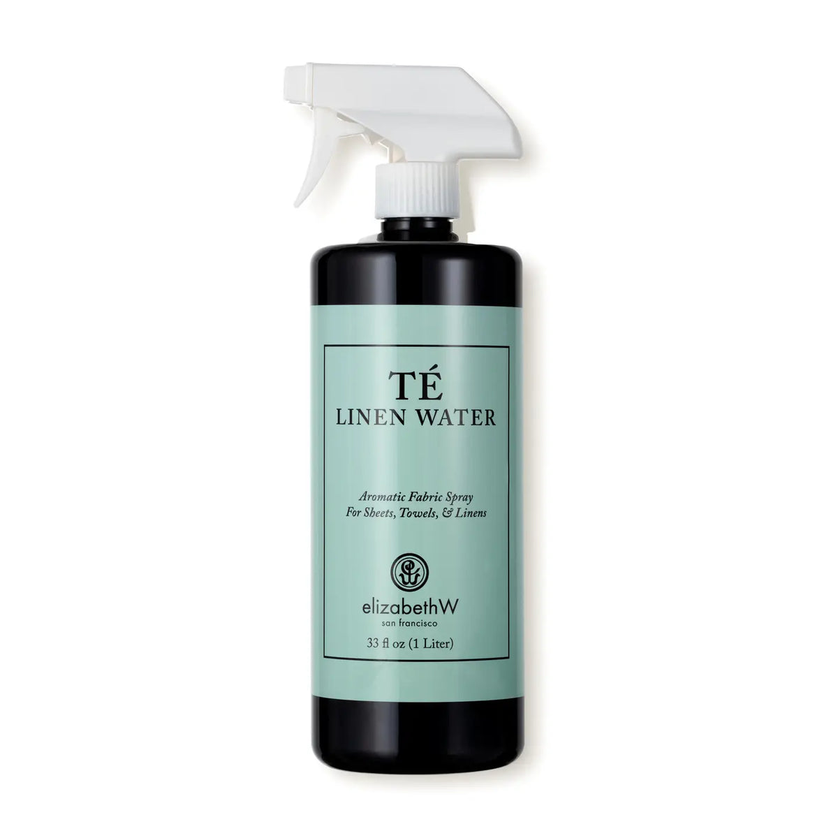 Black glass spray bottle with mint-green label band and white trigger nozzle, labeled TÉ Linen Water aromatic fabric spray