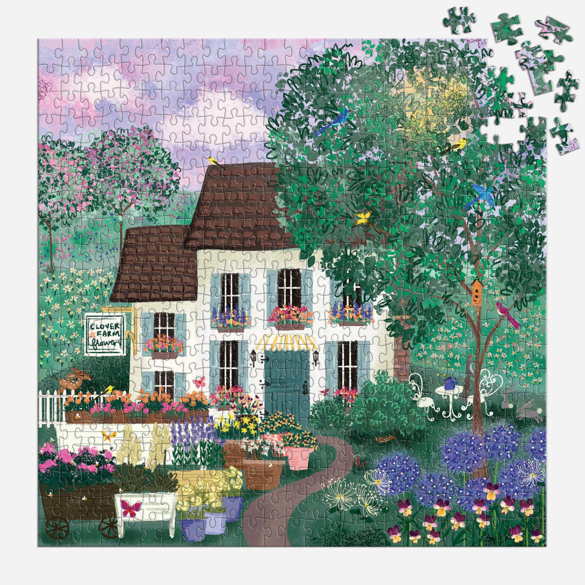 Jigsaw puzzle depicting cream cottage with brown roof nestled in lush garden, colorful blooms and climbing vines, loose pieces scattered