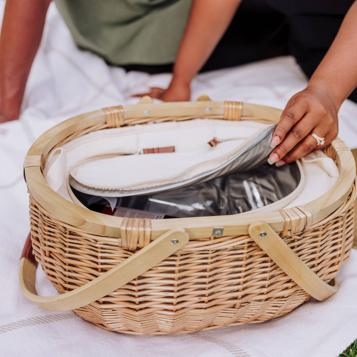 Hand-woven willow picnic basket with beige wicker, canvas handles, and open insulated interior