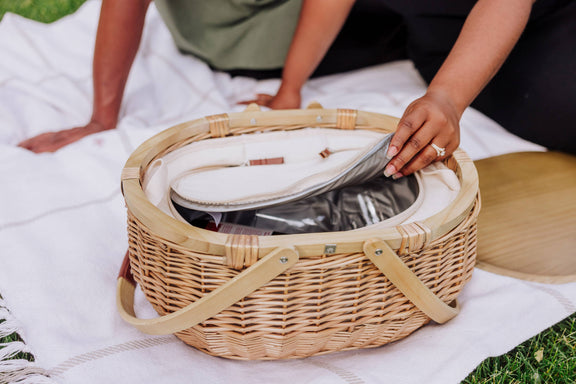 Hand-woven willow picnic basket with beige wicker, canvas handles, and open insulated interior