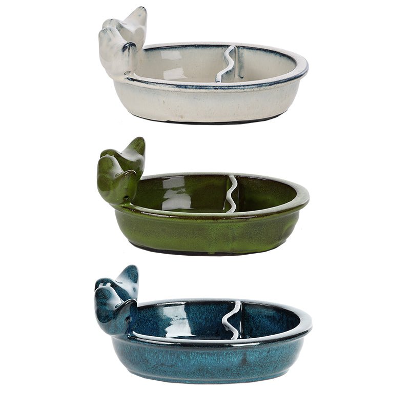 Three ceramic bird baths with bird-shaped perches in white, sage green, and teal, each with glazed interiors and decorative rim detail