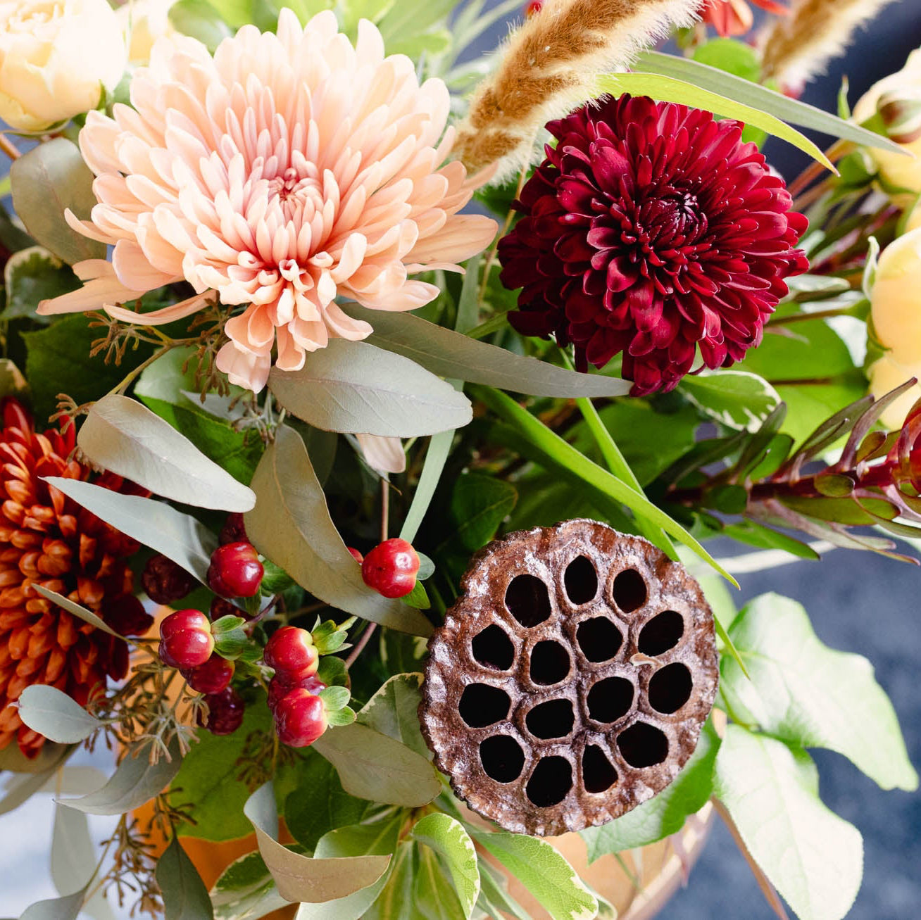 Bouquet of flowers with red, orange, and pink colors against a blurred background