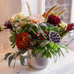 Bouquet of flowers in a silver vase on a tiled surface