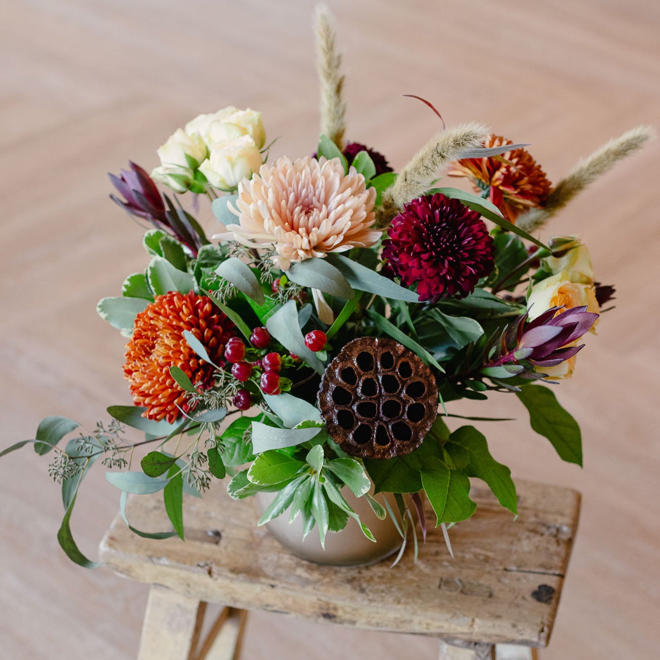 Bouquet of flowers on a wooden stool with a neutral background