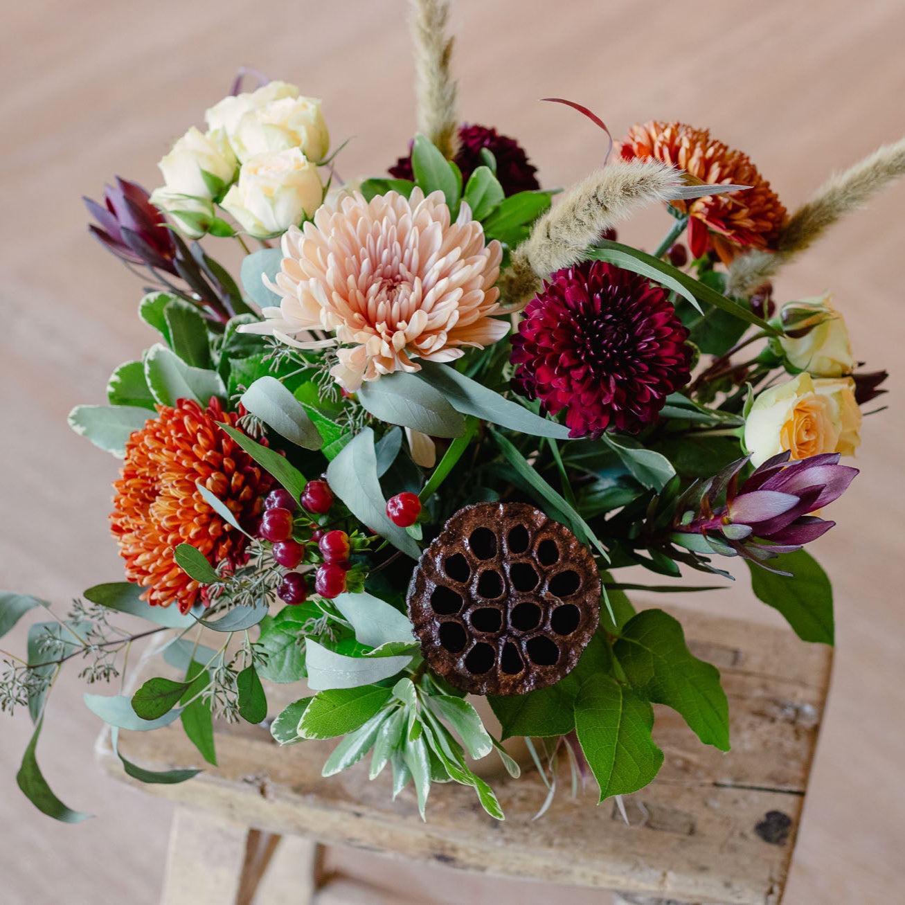 Bouquet of flowers on a wooden stool with a neutral background