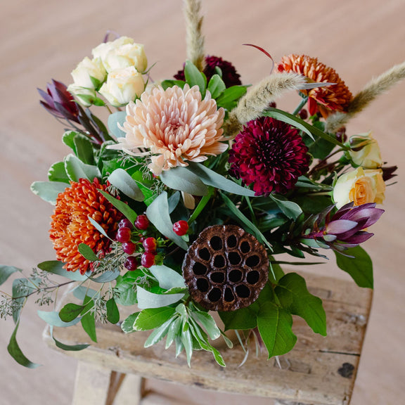 Bouquet of flowers on a wooden stool with a neutral background