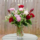 Bouquet of flowers in a vase on a wooden table with a wooden fence background
