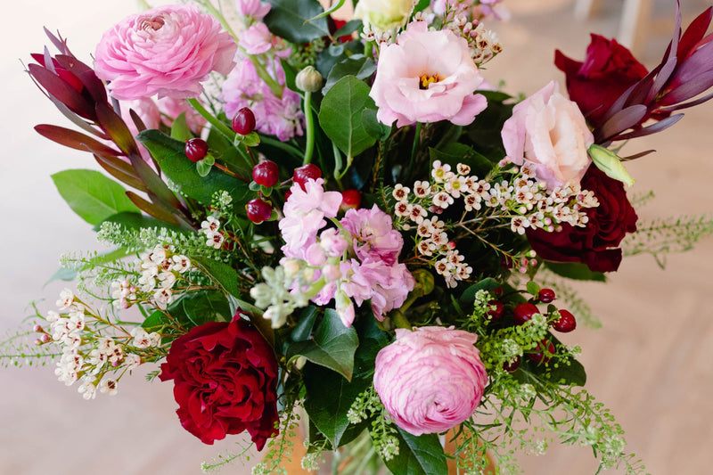 Bouquet of flowers with pink, red, and white flowers on a blurred background