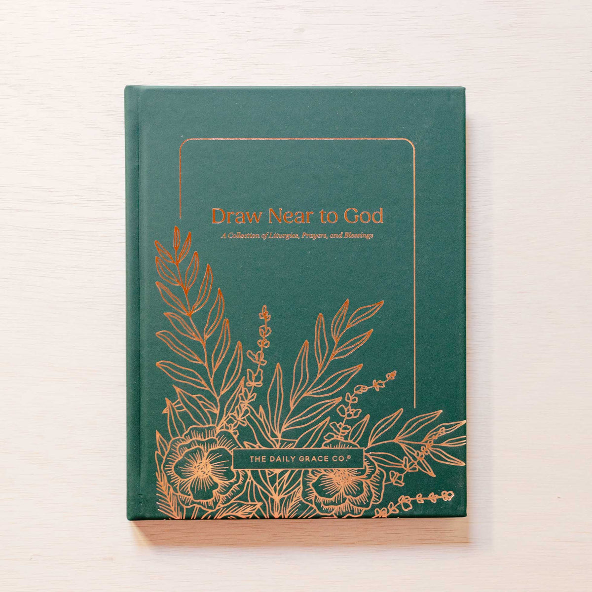 Teal linen hardcover prayer book with gold foil botanical leaf and floral illustrations and "Draw Near to God" title