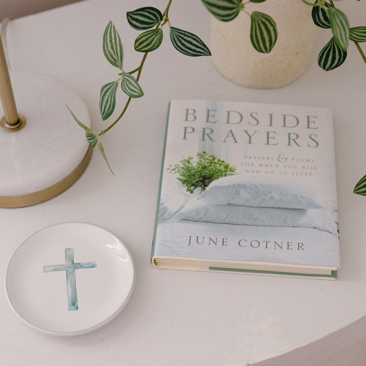 Book titled 'Bedside Prayers' by June Cotner on a white surface with decorative items.