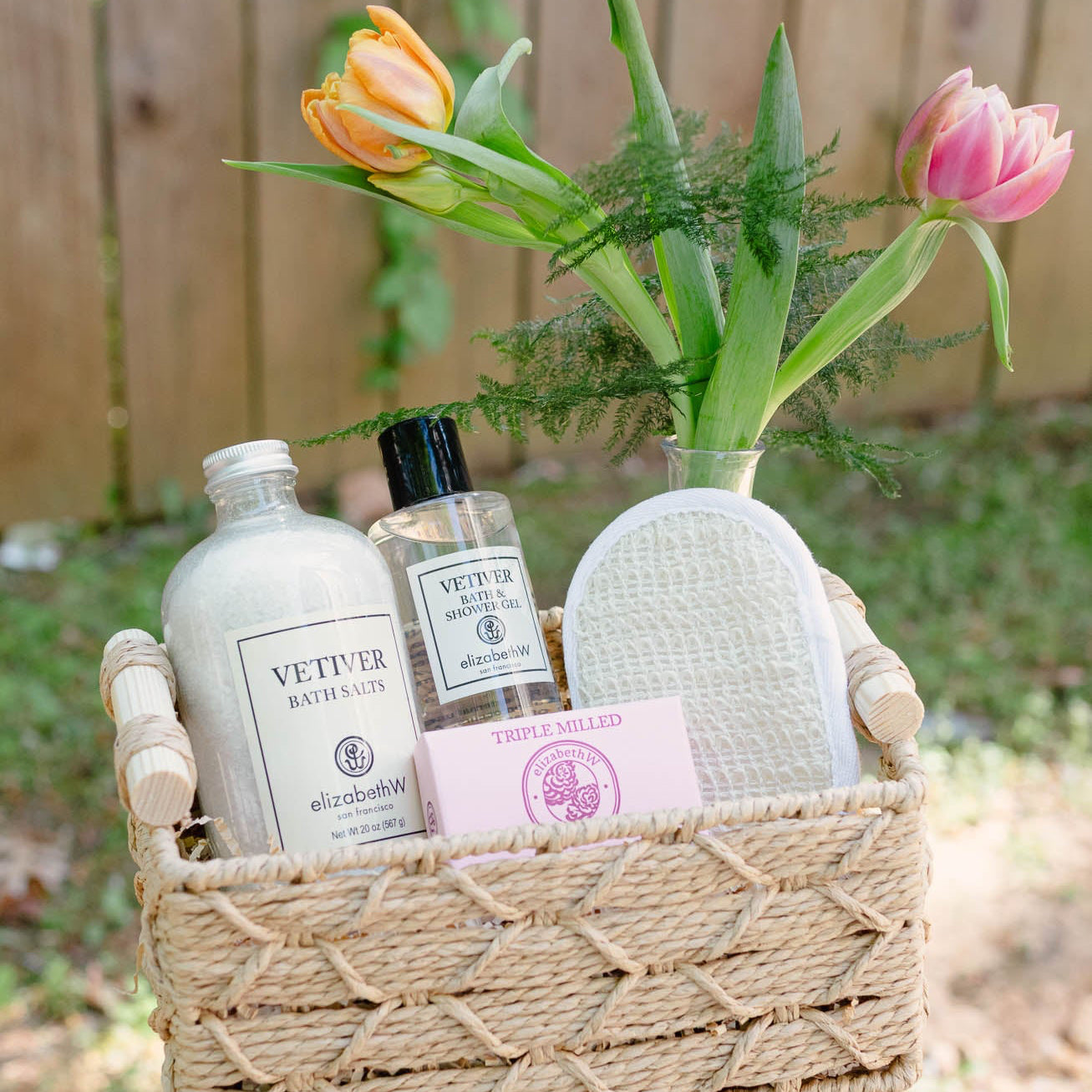 Basket with bath products and flowers on a stand outdoors