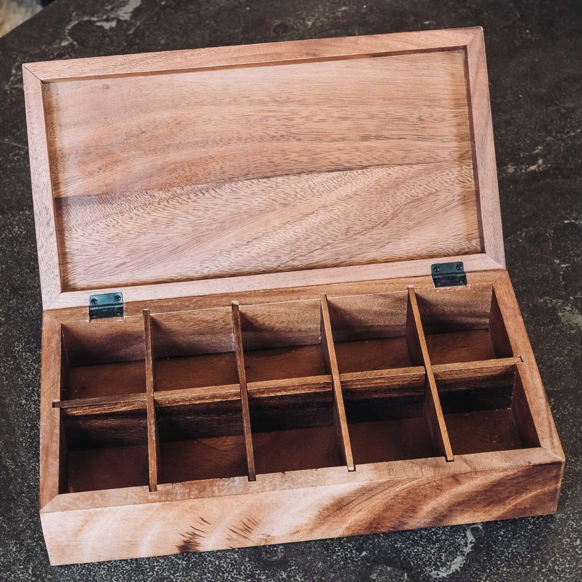 Light wood tea box with open lid, showing 10 divided compartments with metal hinges