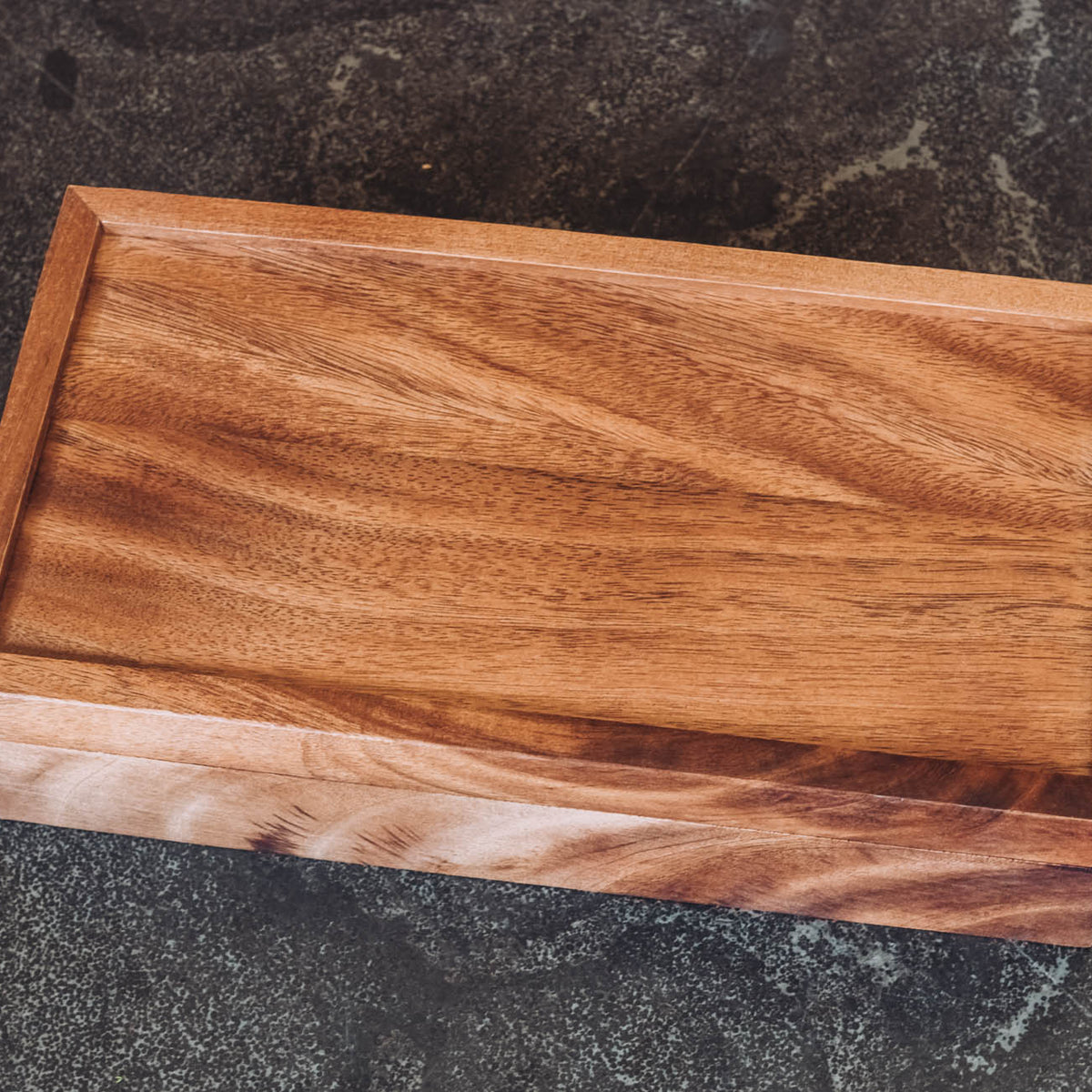 Rectangular wooden tea box in warm medium-brown acacia with open storage and natural wood grain visible
